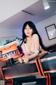 A woman sitting at a video game machine.